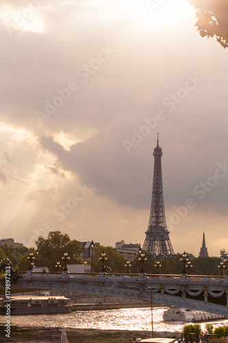 Eiffel tower and Alexandre III bridge close to the Seine river, Paris symbol and iconic landmark in France, on a cloudy day. Famous touristic places and romantic travel destinations in Europe