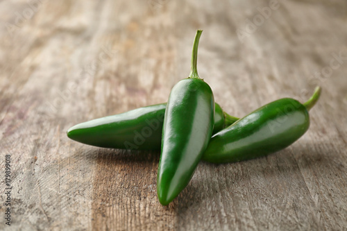 Green jalapeno peppers on wooden background photo