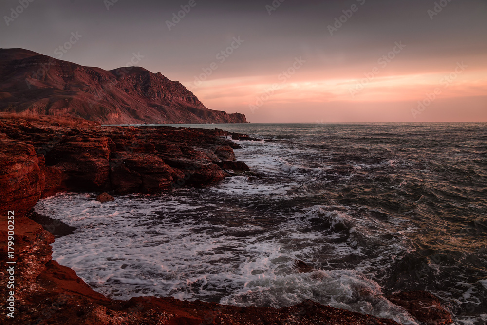 Storm sea at sunset on the mountain coast