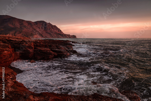 Storm sea at sunset on the mountain coast