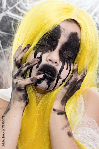 Portrait of young woman with yellow hair with scary halloween makeup