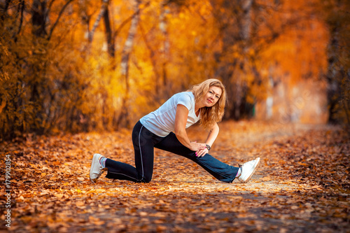 beautiful woman doing yoga outdoors in autumn