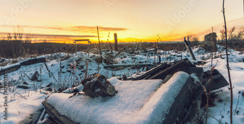 The post-apocalyptic world.Nuclear winter.Old gas mask in the ruins. The remains of houses covered with snow at sunset