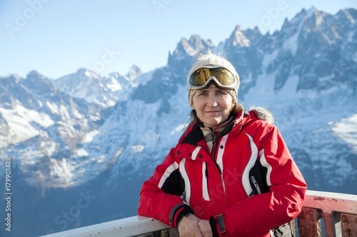 a middle-aged woman in a ski mask in winter mountains on Sunny day