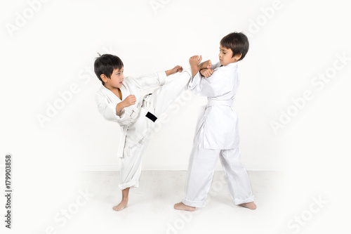 two boys of the karateka in a white kimono battle or train