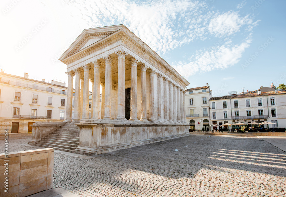View on the ancient Roman temple Maison Carree during the sunny morning in Nimes in the Occitanie region of southern France