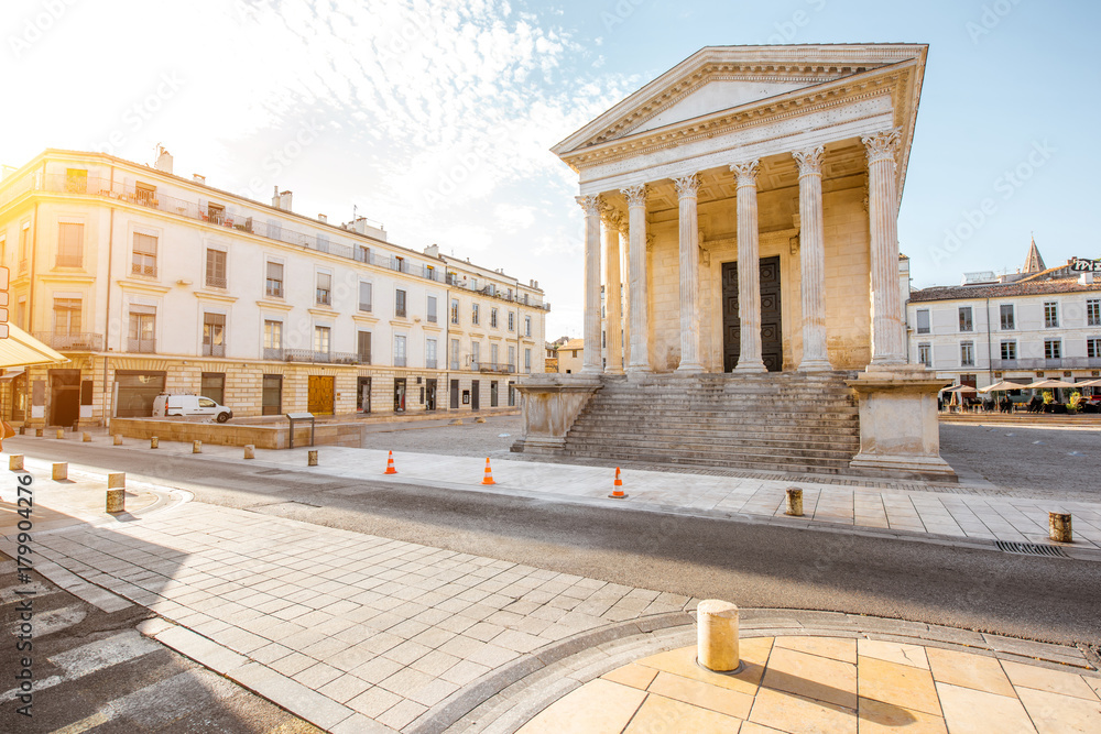 View on the ancient Roman temple Maison Carree during the sunny morning in Nimes in the Occitanie region of southern France