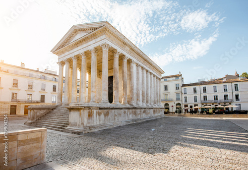 View on the ancient Roman temple Maison Carree during the sunny morning in Nimes in the Occitanie region of southern France photo