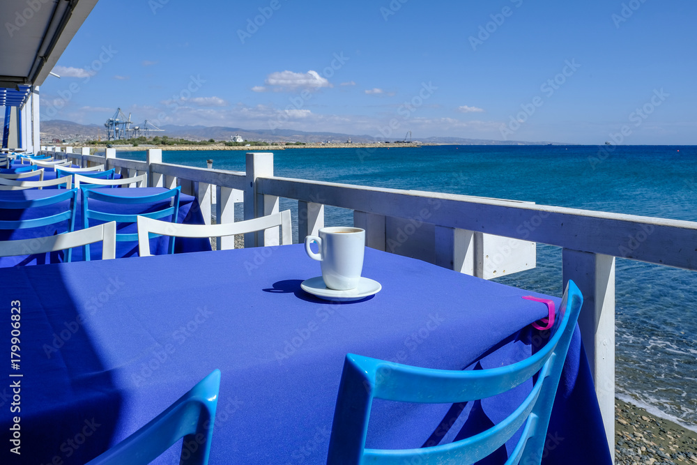 Having coffee on a blue table beside the sea in Limassol, Cyprus