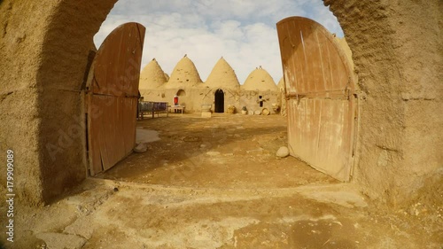 a wooden gate and a courtyard in a clay Arab village, near the border between Turkey and Syria