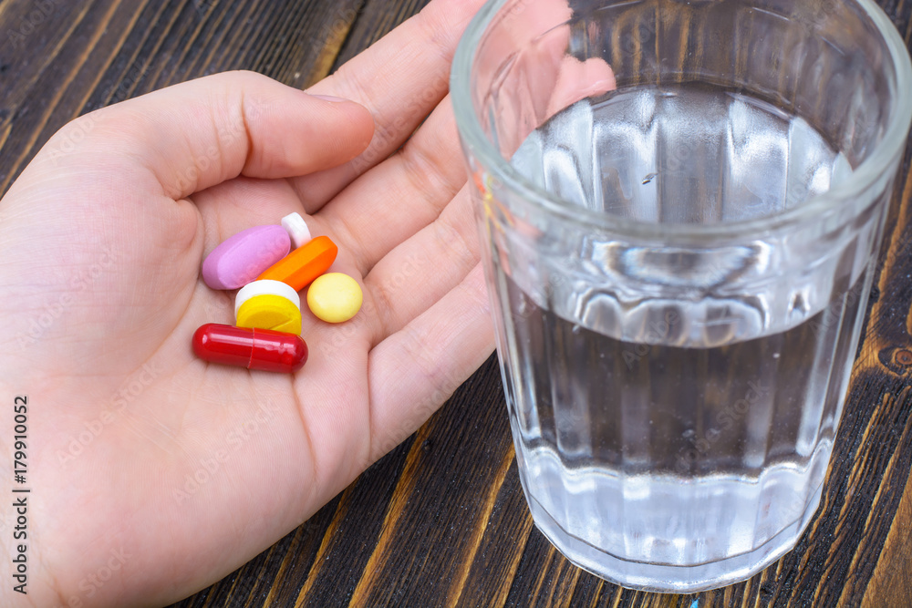 Different pills and capsules in the palm of your hand Different pills and capsules in the palm of your hand