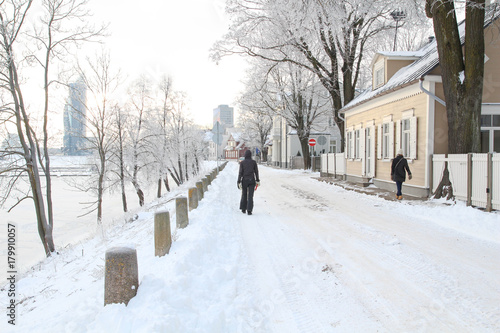 People Walking Streets. Snow Pictures. Walk along snow covered street © dainav
