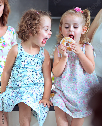 Cute chlidren eating sweet doughnuts photo