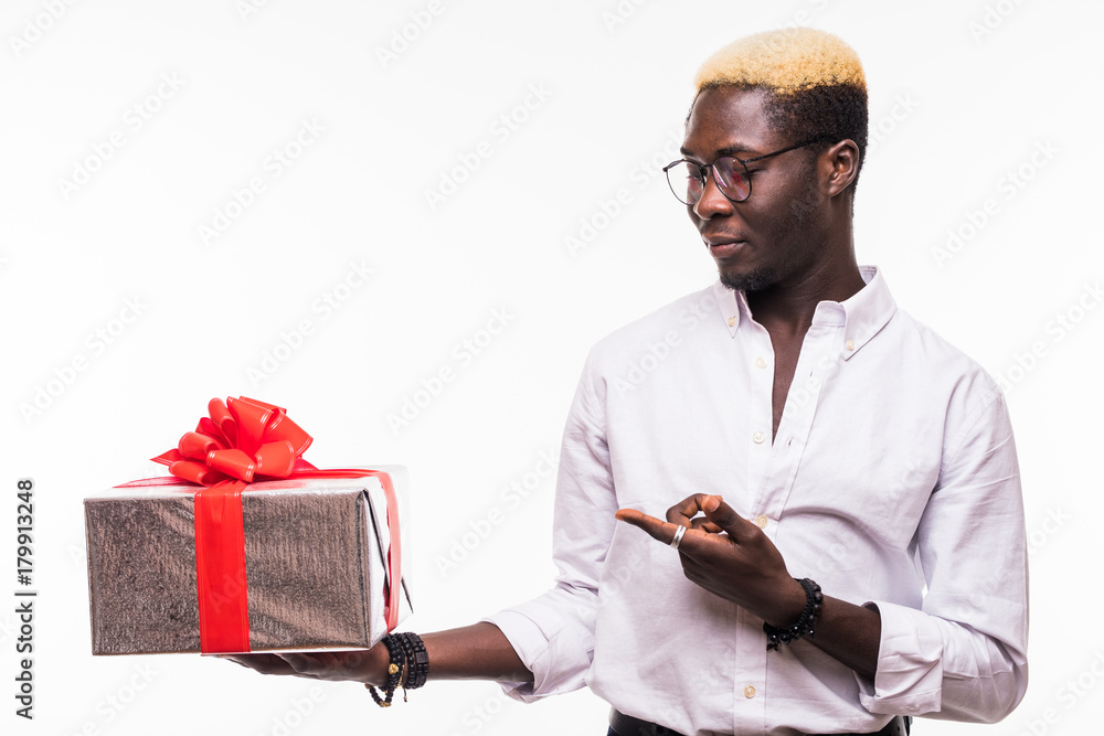 Handsome cool black man with a gift pointed on with finger on white background