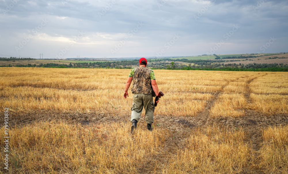 Hunter moving with shotgun looking for prey. Hunter moving with shotgun looking for prey.