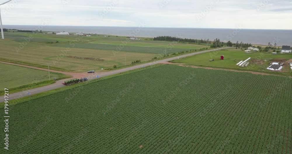 Following tractor driving down road with crops - agriculture Following tractor driving down road with crops - agriculture