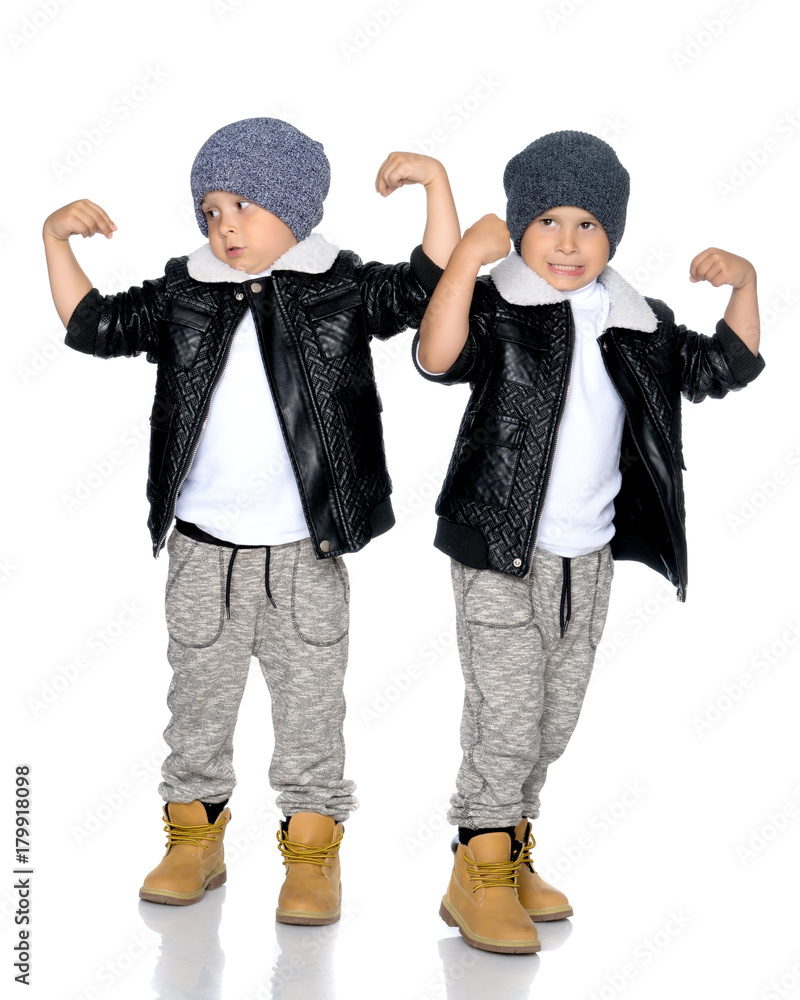Two little boys in black jackets and hats. Two little boys in black jackets and hats.