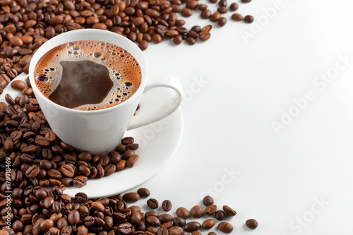 A cup of hot coffee with coffee beans on a white background