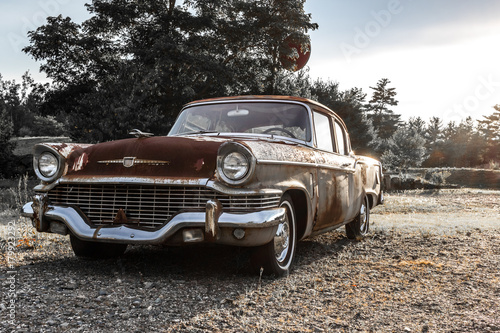 Circa 1957 old rusted vintage Studebaker 2 door car on the side of a road in Holden, Maine. Taken July 2017