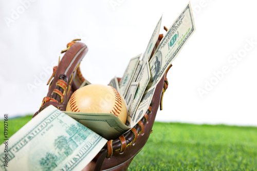 Photography Close up of  baseball in a Glove with dollar bills in concept of getting money w