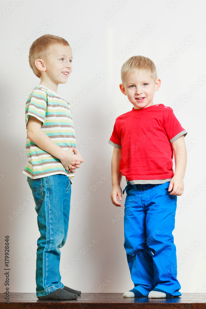 Two little boys siblings playing together on table Two little boys siblings playing together on table