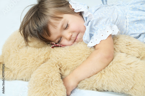 Little girl happy sleeping smiley with Teddy bear hugging toy