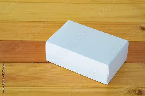 Empty white gift box for mock up on wooden table with copy space. © pookpiik