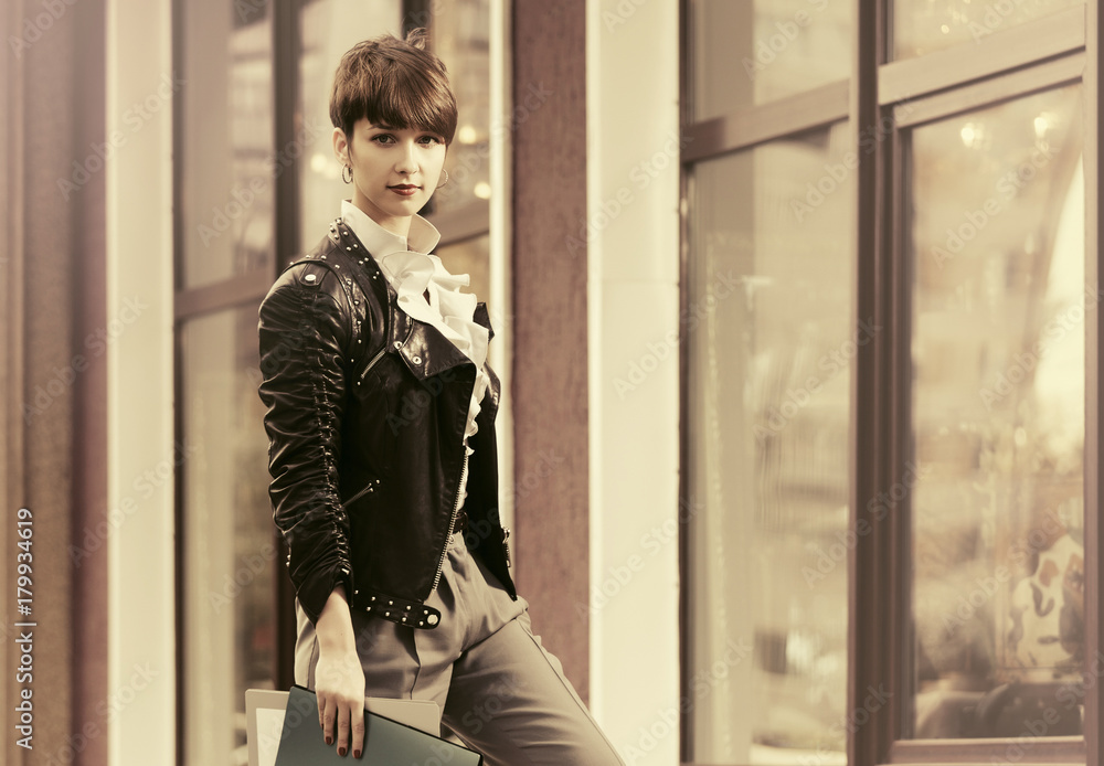 Happy young fashion business woman in leather jacket with a folders at office building Happy young fashion business woman in leather jacket with a folders at office building