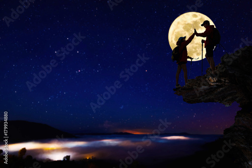 Teamwork hiking help each other trust assistance at mountains and beautiful full moon,teamwork and hiking concept.