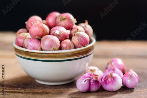 Fresh shallots in a bowl and wooden background, spice and herb, food ingredient
