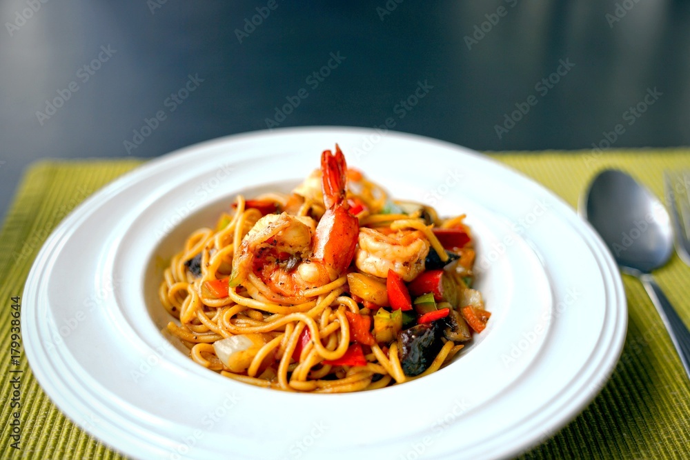 Spaghetti with Thai Spicy Herbal Sauce and prawns on white plate