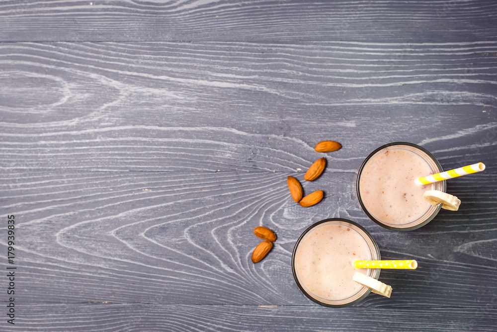 Banana milk smoothie with almonds on gray wooden background Banana milk smoothie with almonds on gray wooden background