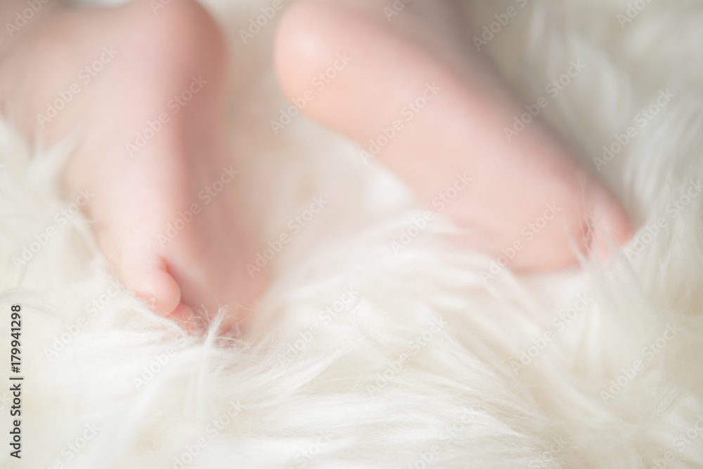 Bare feet of a cute newborn baby in warm white blanket. Childhood. Small bare feet of a little baby girl or boy. Sleeping newborn child. Bare feet of a cute newborn baby in warm white blanket. Childhood. Small bare feet of a little baby girl or boy. Sleeping newborn child.