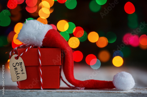 Christmas present or box for secret santa with Santa hat. Greeting card.
