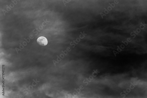 View of the moon through some clouds in the sky