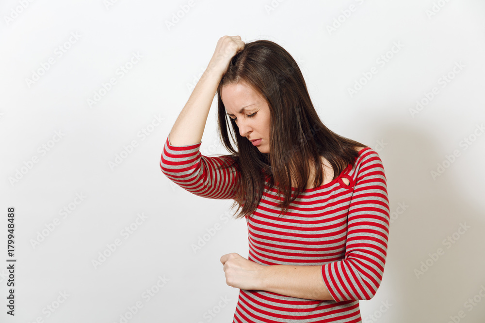 Pretty European worried and pensive brown-haired woman with healthy clean skin and headache, dressed in red and grey clothes lost in thought and conjectures, on a white background. Emotions concept. Pretty European worried and pensive brown-haired woman with healthy clean skin and headache, dressed in red and grey clothes lost in thought and conjectures, on a white background. Emotions concept.