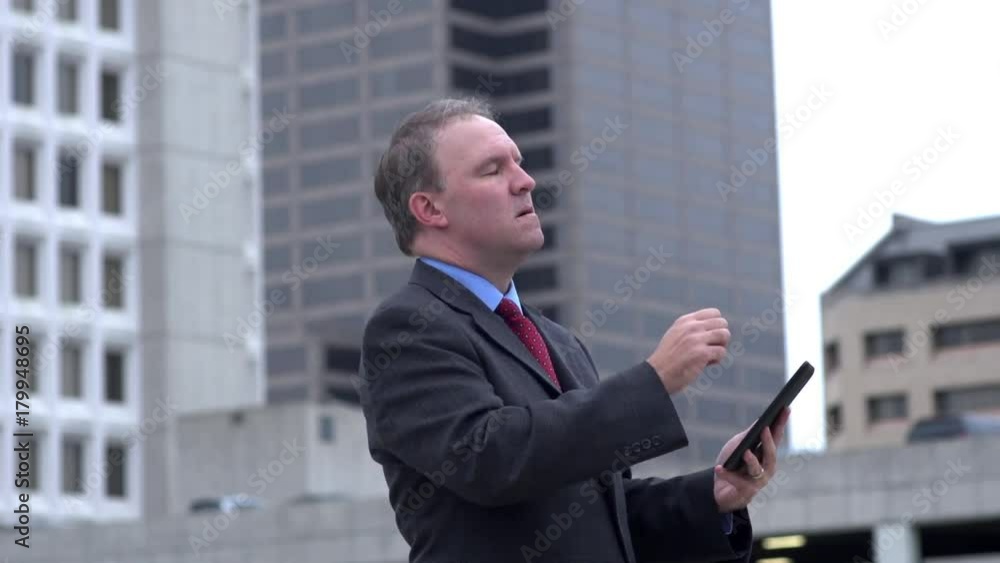 Businessman reads disappointing news on tablet and reacts Businessman reads disappointing news on tablet and reacts