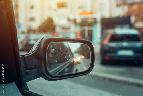 Reflection of city traffic in car side mirror