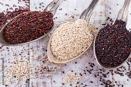Red, black and white quinoa seeds on a wooden background © id-art