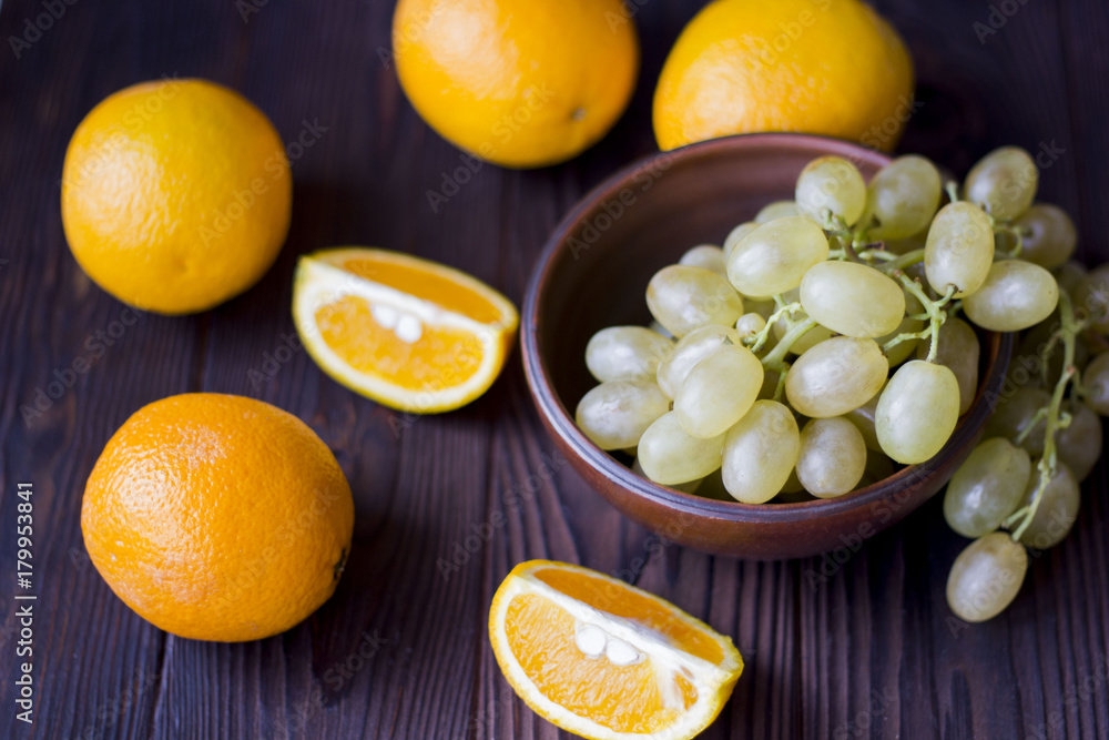 oranges and grapes on wooden background oranges and grapes on wooden background