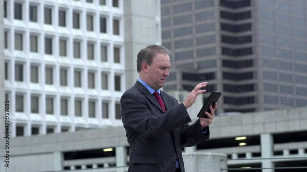 Businessma reads exciting news on tablet and celebrates Businessma reads exciting news on tablet and celebrates