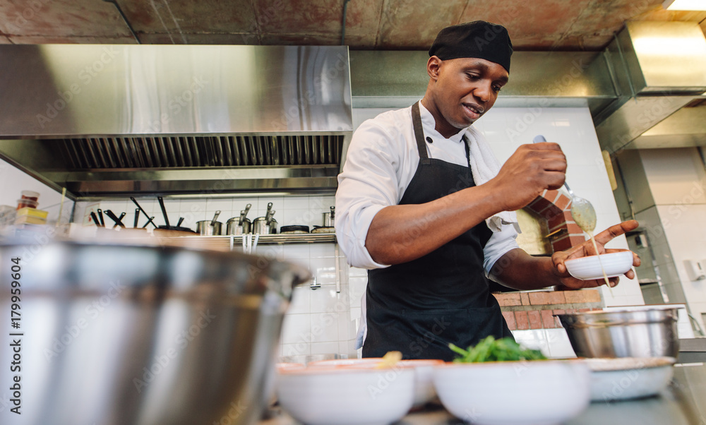 Chef cooking food in restaurant kitchen Chef cooking food in restaurant kitchen