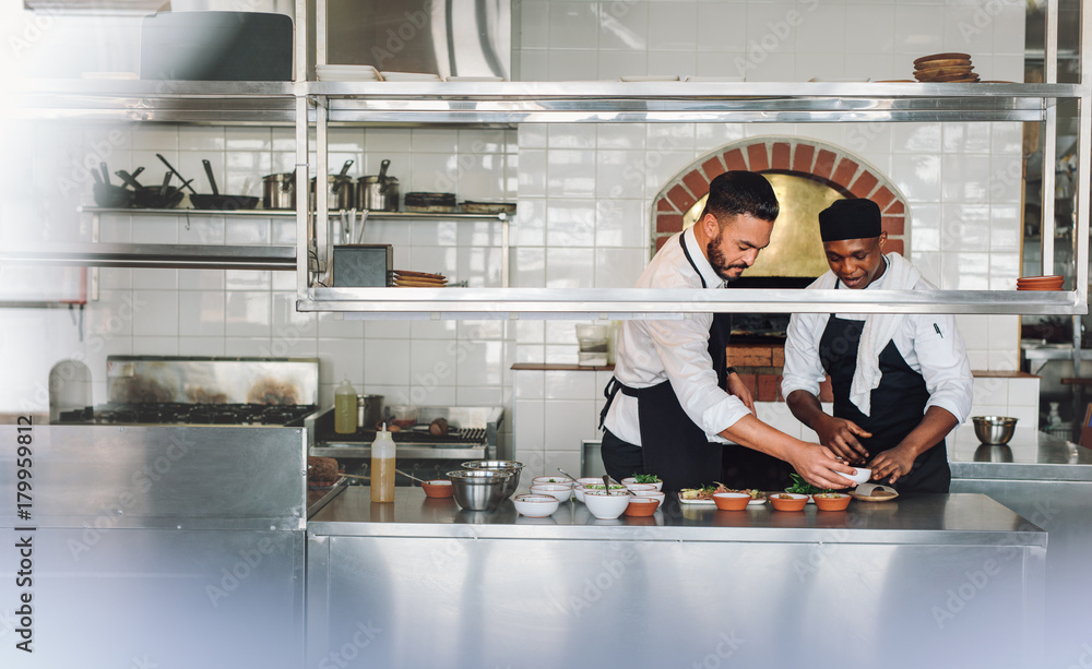 Chefs cooking food at commercial kitchen Chefs cooking food at commercial kitchen