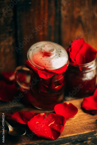 tea made from tea rose petals in a glass bowl on wooden rustic background/ toned image photo