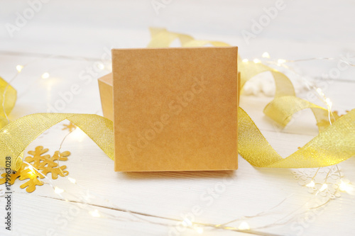 Gold kraft gift box on white wooden background photo