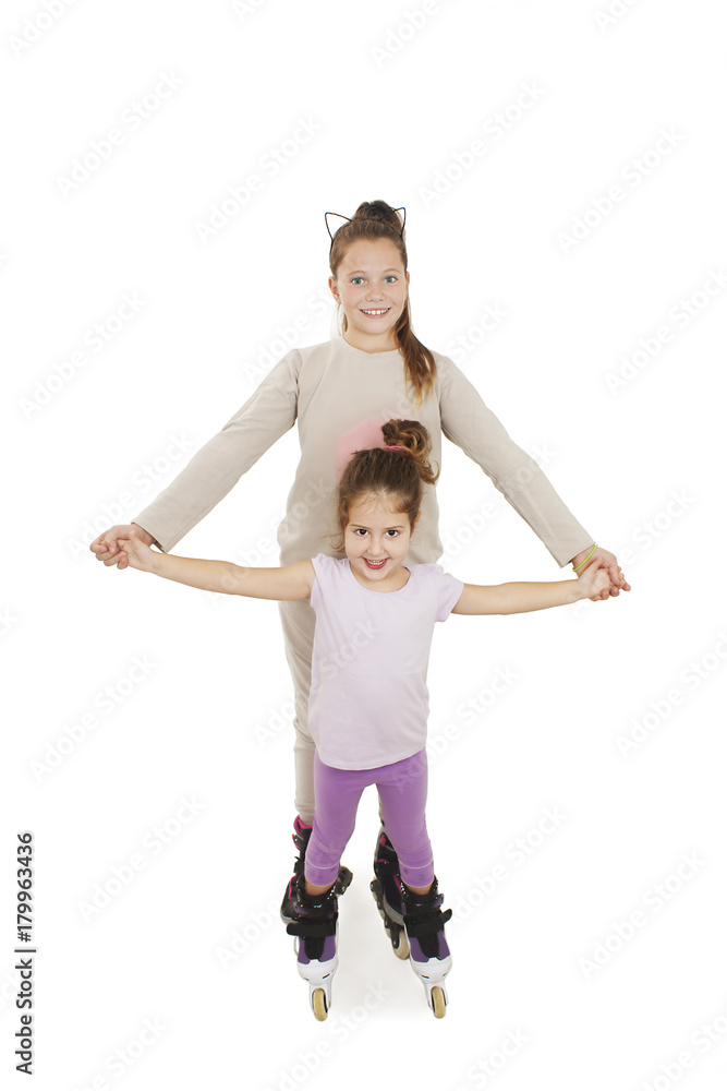 Two cute girls holding hands wearing roller skates. Isolated on a white background Two cute girls holding hands wearing roller skates. Isolated on a white background