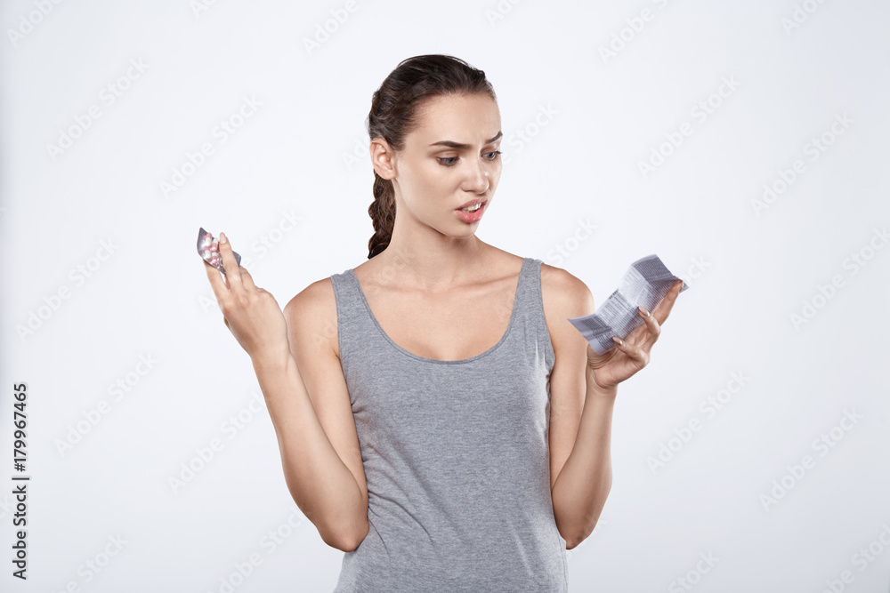 Portrait of attractive woman holding pills and direction at studio Portrait of attractive woman holding pills and direction at studio