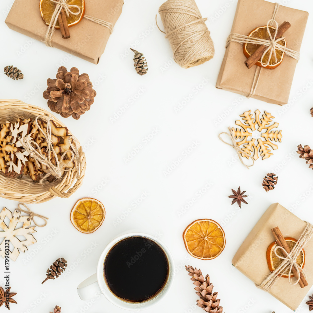 Frame with Christmas decoration, craft gift box, coffee mug and pine cones on white background. Flat lay, top view Frame with Christmas decoration, craft gift box, coffee mug and pine cones on white background. Flat lay, top view