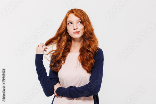 Thinking cute young redhead lady