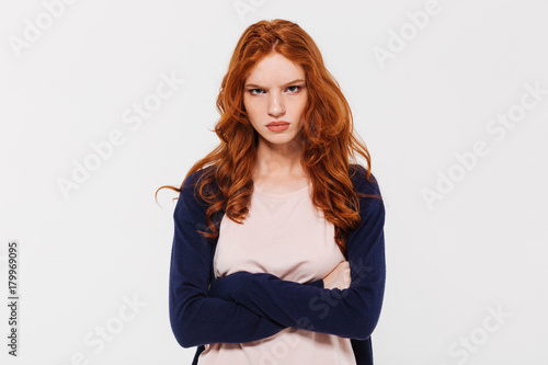 Angry pretty young redhead lady with arms crossed. photo